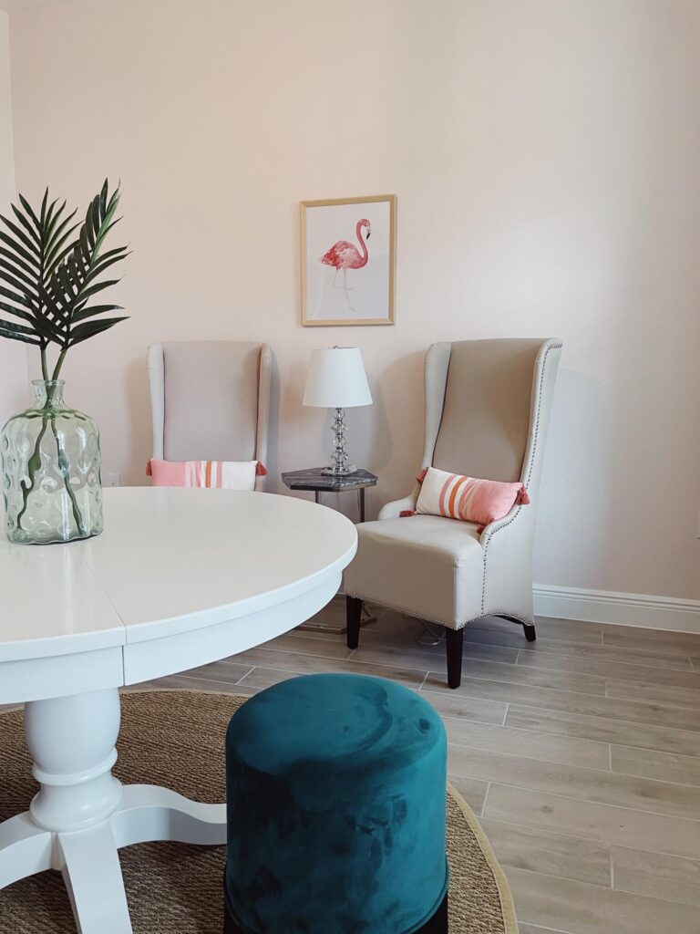 Light pink sitting room with beige chairs and green stools