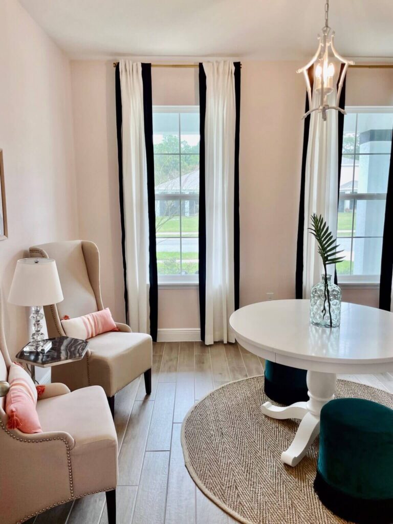 Light pink sitting room with white and black curtains