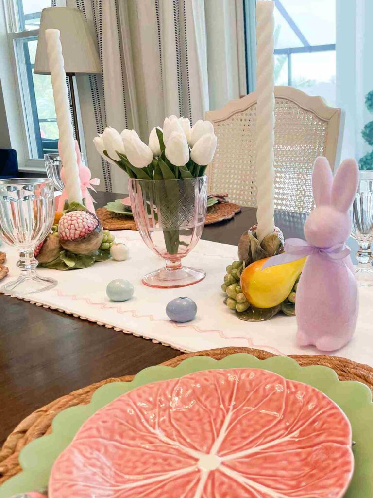 Vase with tulips and taper candles on a table decorated for Easter